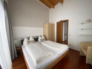 1 dormitorio con 1 cama con sábanas y almohadas blancas en Chalet Elisabeth en Flachau