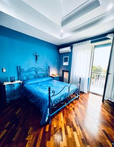 een blauwe slaapkamer met een bed en een groot raam bij RaRoom Colors in Portici