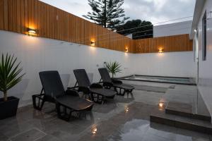 a group of chairs sitting on a patio with a pool at Casa de Santa Catarina - Ponta Delgada in Ponta Delgada