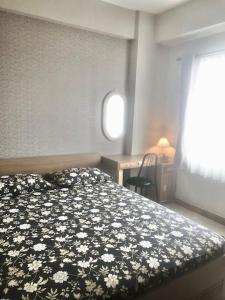 a bedroom with a bed with a black and white floral bedspread at Apartemen Ciumbuleuit 2 in Bandung