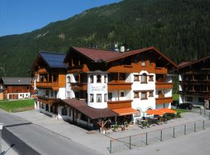 ein großes Gebäude mit einem Berg im Hintergrund in der Unterkunft Hotel zum grünen Tor in Tux