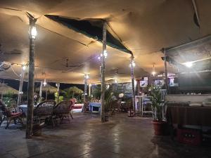 Un patio con mesas y sillas bajo una carpa. en Casa fiesta Sea front beach huts, en Patnem 70 fotos más