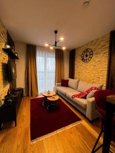 a living room with a couch and a brick wall at Apartman Carra in Jahorina