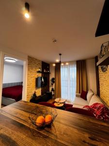 a living room with a large wooden table with oranges on it at Apartman Carra in Jahorina