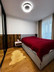 a bedroom with a large bed with a red blanket at Apartman Carra in Jahorina +6 photos