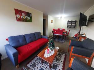 - un salon avec un canapé rouge et un arbre de Noël dans l'établissement DEPARTAMENTO COSTANERA PELLUCO, PUERTO MONTT, à Puerto Montt