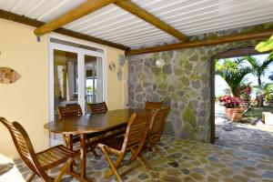 a dining room with a wooden table and chairs at Fenetre sur Mer in Rodrigues Island