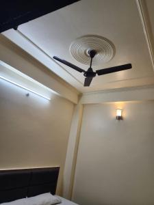 a ceiling fan in a room with a bed at K K RENUKA DHARAMSHALA in Haridwār
