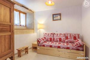 1 dormitorio con 1 cama con almohadas rojas y blancas en Gite Les Nièces - 4-6pers 57m2 Valmeinier - Ski, en Valmeinier