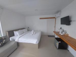 Dormitorio pequeño con cama y TV en White house bailan resort, en Ko Chang