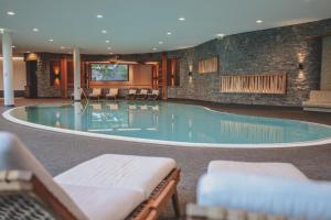 una grande piscina con sedie in un edificio di PRIVÀ Alpine Lodge a Lenzerheide