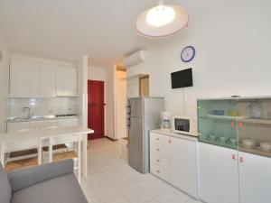 una cucina con frigorifero e tavolo con orologio di Modern two-room apartment Condominio Nautilus Bibione a Bibione