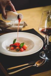 una persona vertiendo salsa en un plato de comida en PRIVÀ Alpine Lodge en Lenzerheide