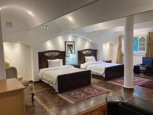 a bedroom with two beds and a living room at Al Fardous Luxury Vacation Home in King Mariout