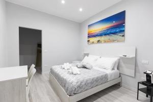 una camera bianca con un letto e un dipinto sul muro di B&B Chiaro di Luna a Barletta