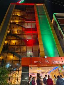 a building with colored windows and people walking in front of it at Hotel MN Grand Shamshabad Near RGI Airport Hyderabad in Shamshabad