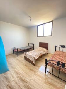 a room with three beds and a window at Apartment in madba in Madaba