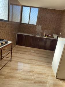 a kitchen with wooden cabinets and a tile floor at Apartment in madba in Madaba