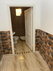 an open bathroom with a toilet and a brick wall at Apartment in madba in Madaba