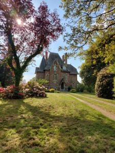 an old brick house with a yard in front of it at Le Manoir des Rochers in Bouère