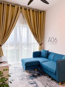 a living room with a blue couch and a window at SUWAN Guesthouse A06 - 2BR Apartment with Pool Near UKM in Kajang