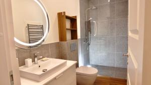 a bathroom with a sink and a shower with a mirror at Žalio kalno apartamentai in Kaunas