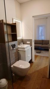 a bathroom with a toilet and a sink and a couch at Žalio kalno apartamentai in Kaunas
