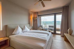 una camera da letto con un letto grande e una grande finestra di Sonne Seehotel a Eich