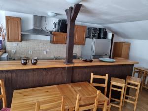 a kitchen with a wooden table and some chairs at Penzion U našich in Mladé Buky