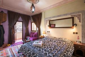 a bedroom with a large bed and a mirror at Atlas Prestige in Imlil