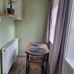a small table with two stools in a room at Belvárosi Pihenőház in Békéscsaba