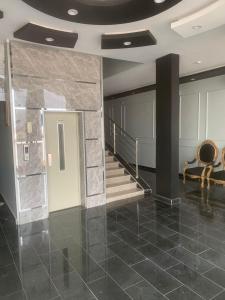 vestíbulo con escalera y pared de piedra en Orchida Turaif Hotel 1, en Turaif