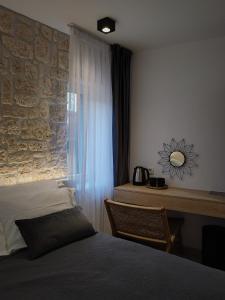 a bedroom with a bed and a stone wall at ST. CLARA OLD TOWN in Šibenik