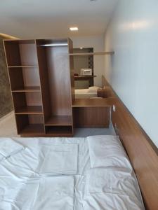 1 dormitorio con cama y estante para libros en Victory Flat Tambaú BR, en João Pessoa