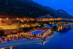 an aerial view of a resort on the water at night at Doria Hotel Yacht Club Kaş in Kas