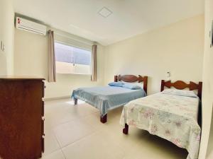 a bedroom with two beds and a window at Casa Jacuípe in Camaçari