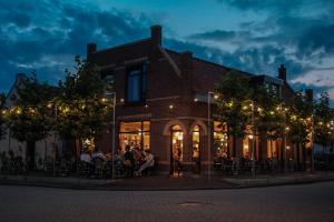 eine Gruppe von Personen, die außerhalb eines Gebäudes sitzen in der Unterkunft Café Koophandel in Ouddorp