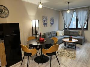 a living room with a couch and a table and chairs at Borovets Gardens one bedroom apartment in Borovets