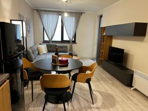 a living room with a table and chairs and a couch at Borovets Gardens one bedroom apartment in Borovets