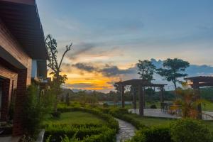 a sunset view of a garden with a patio at Emopea Moc Chau in Mộc Châu
