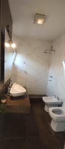 uma casa de banho com um WC, um bidé e um lavatório. em Hermosa Casa Vistalba em Ciudad Lujan de Cuyo
