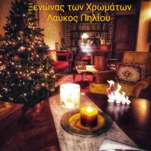 a living room with a christmas tree and a candle at Xenonas ton Chromaton in Lafkos