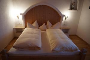 1 cama con cabecero de madera y almohadas en Apart Martha, en Zellberg