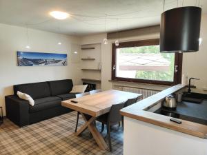 a living room with a couch and a table at Hostdomus - Helsinki Suite in Sestriere