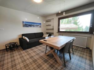 a living room with a table and a couch at Hostdomus - Helsinki Suite in Sestriere