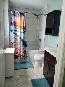 a bathroom with a shower curtain and a toilet at KL Retreat 4BR4BTH with Jacuzzi and game room! in Key Largo