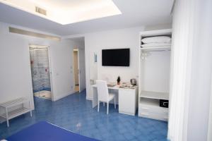 a white room with a desk and a tv in it at Domus Sole in Sorrento