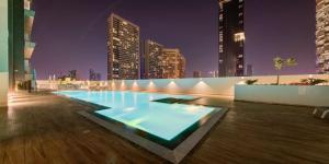 una piscina en medio de una ciudad por la noche en Big Modern Studio in Park View JVC en Dubái