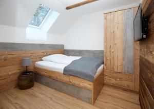 1 dormitorio con 1 cama con pared de madera en Grafhaidergut - Auszeit am Land, en Wartberg an der Krems