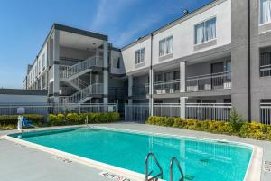 um edifício de apartamentos com uma piscina em frente a um edifício em Quality Inn Near Fort Liberty formerly Ft Bragg em Fayetteville